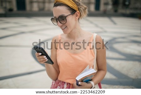 Travel woman using smart phone and tourist guidebook and wandering the city 
