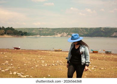 Travel Woman Walking On The Shore Of The Lake After Being A Passenger In A Boat Touring The Area