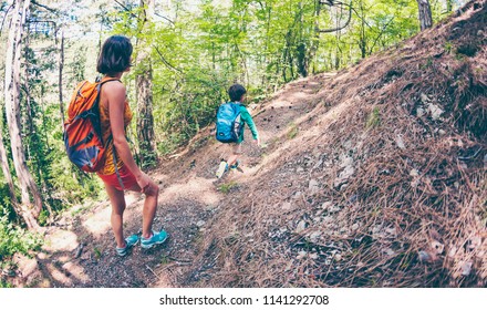 travel in the woods with a child. the boy and his mother walk along the forest path during the hike. the boy and his mother carry backpacks. - Shutterstock ID 1141292708