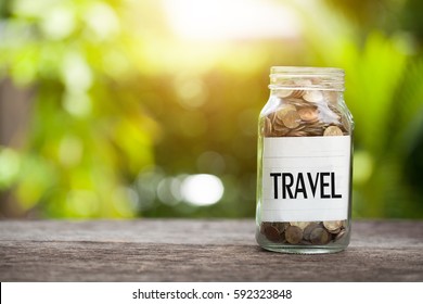 TRAVEL Word With Coin In Glass Jar With Savings And Financial Investment Concept.