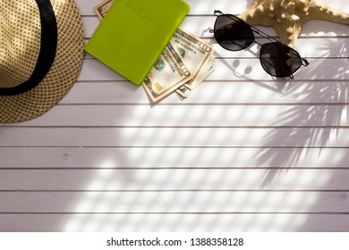 Traveler Accessories, Passport With Cash Money US Dollars, Tropical Palm Leaf Branches On White Background With Empty Space For Text. Travel Vacation Concept. Summer Background. Flat Lay, Top View.