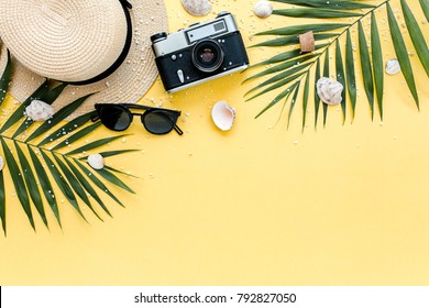 Traveler accessories, tropical palm leaf branches on yellow background with empty space for text. Travel vacation concept. Summer background. Road frame set. Flat lay, top view. - Powered by Shutterstock