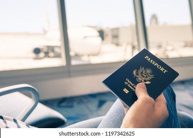 Traveler at airport holding United States passport in hand.  - Powered by Shutterstock