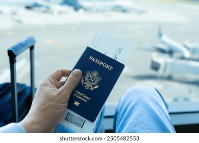 Traveler at the airport with USA passport in hand - Powered by Shutterstock