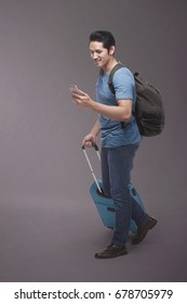 Traveler Asian Man With Backpack Using Smartphone Over Dark Background