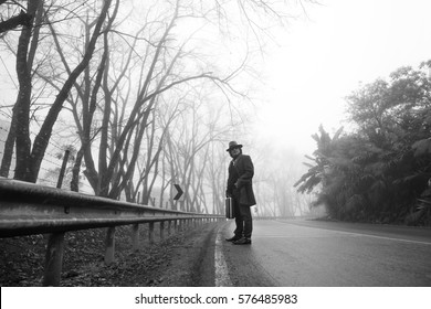 Traveler Asian Man With A Long Coat. Foggy Misty Road