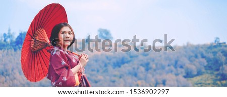 Traveler asian woman with kimono and red Japanese umbrella against sakura flower background, Spring travel vacation concept