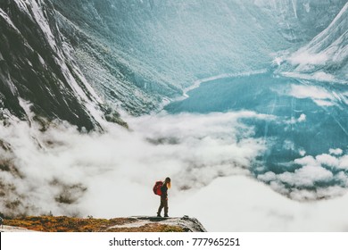 Traveler With Backpack Hiking Above Clouds And Lake In Scandinavian Mountains Travel Lifestyle Wanderlust Concept Adventure Active Vacations Outdoor