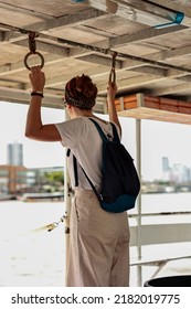 Traveler With Backpack Holding Grab Handle On Boat. Travel Vacation And Transportation Concepts.