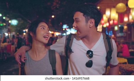 Traveler Backpacker Asian Couple Travel In Bangkok, Thailand, Sweet Couple Drinking Alcohol Or Beer While Hangout At The Khao San Road. Couple Travel In Thailand Concept.