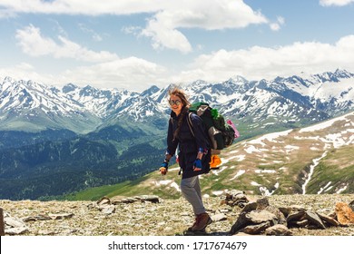 Traveler backpacker on mountains cliff hiking enjoy landscape. Hair fluttering in the wind, cheerful positive hipster girl. Travel Lifestyle concept adventure active vacations outdoor aerial view.
