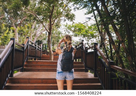 Traveler blonde backpacker woman  walking taking photos in tropical park, Travel adventure nature in China, Tourist beautiful destination Asia, Summer holiday vacation trip, Copy space for banner
