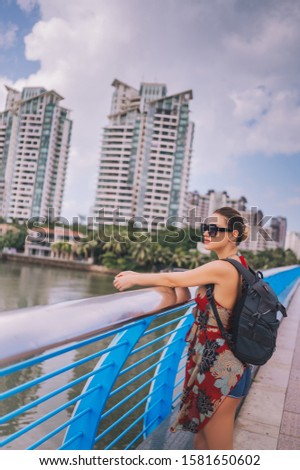 Traveler blonde backpacker woman  walking in Asian city downtown with skyscrapers. Travel adventure nature in China, Tourist beautiful destination Asia, Summer holiday vacation journey trip concept