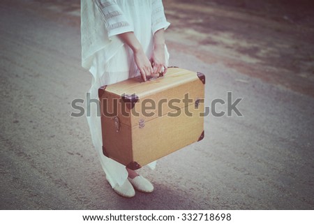 Traveler carrying luggage on the road. Portrait woman in vintage style