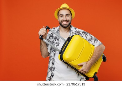 Traveler cheerful tourist man wear summer casual clothes hat hold suitcase bag isolated on plain orange color background studio. Passenger travel abroad on weekends getaway. Air flight journey concept