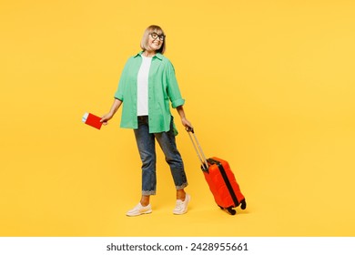 Traveler elderly woman wear green casual clothes hold passport ticket bag isolated on plain yellow background. Tourist travel abroad in free spare time rest getaway. Air flight trip journey concept - Powered by Shutterstock