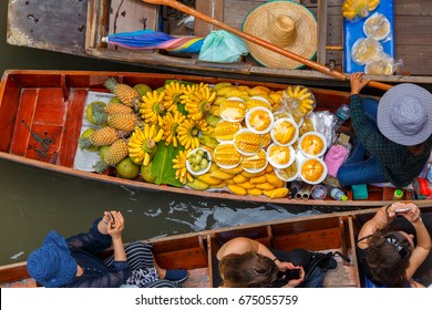 Traveler enjoying and take a photo with smartphone on long trail boat at Damnoen Saduak floating market in Ratchaburi near Bangkok, Thailand