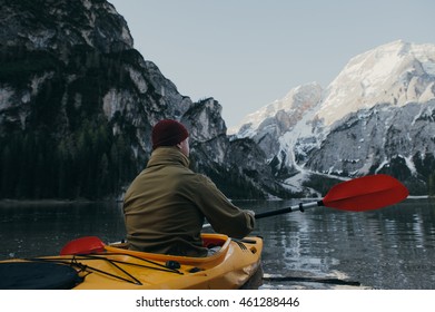 traveler floating on a kayak on mountain lake in Italy