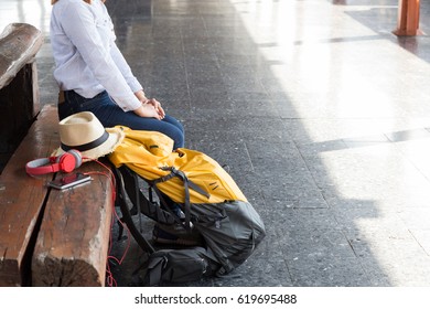 Traveler girl with a backpack sitting and waiting for train on the station. Outdoor adventure travel by train concept - Shutterstock ID 619695488