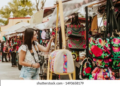 traveler girl buying souvenirs in the traditional Mexican market in Mexico streets, hispanic tourists standing in outdoor