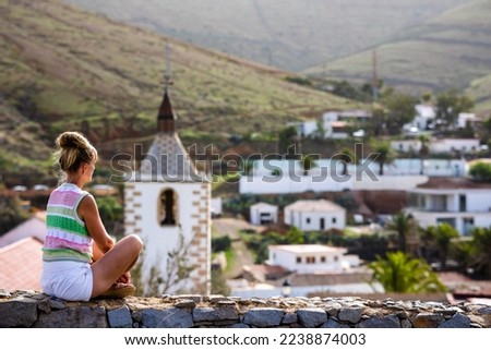 Traveler girl enjoys beautiful view of Betancuria, selective focus, Fuerteventura, Canary Islands, Spain.