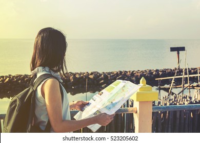 traveler girl looking at the sea with map, travel and active lifestyle concept