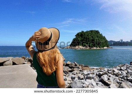 Traveler girl looking the uninhabited Urubuqueçaba Island near Santos coast, Baixada Santista, Brazil