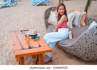 traveler girl in red dress sit on the chair in beach with vacation trip in emotional relax and smile for relax concept - Shutterstock ID 1534049525