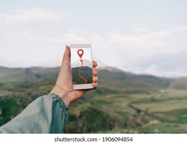 Man hiker using smartphone application navigation in mountains