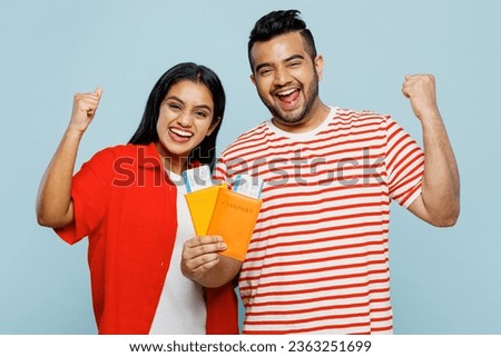Traveler Indian man woman wearing red casual clothes hold passport ticket isolated on plain blue color background Tourist travel abroad in free spare time rest getaway Air flight trip journey concept
