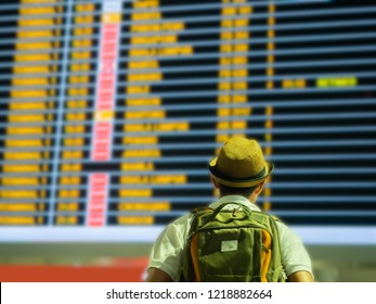 traveler looking time table board in airport terminal for arrival time with boarding time background copy space