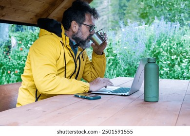 Traveler male drinking coffee in morning outdoor leisure activity using laptop with roaming everywhere connection. Mature man busy in remote work digital nomad technology business in alternative place - Powered by Shutterstock