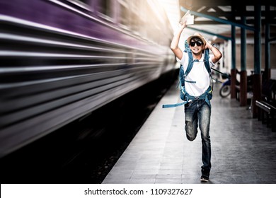 Traveler Man Running After A Moving Train From A Railway Station