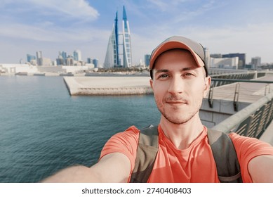 Traveler man smiling while capturing a selfie overlooking the Bahrain cityscape and waterfront
