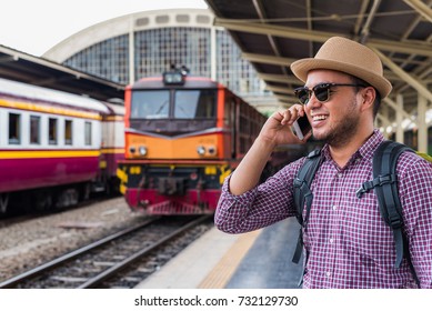 Traveler man talk to phone at train station - Powered by Shutterstock