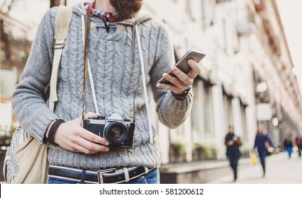 Traveler Man Using Mobile Phone In The Street. Active Lifestyle And Travel Concept