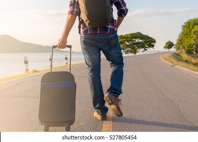 Traveler Man Walking With Suitcase In The Street. Travel Concept.