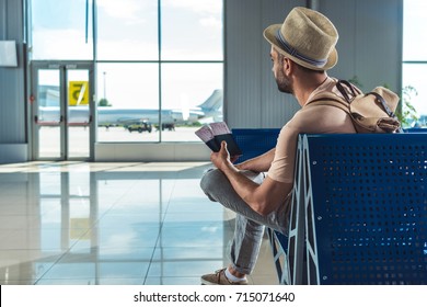 Traveler With Passports And Tickets Waiting For Someone In Airport