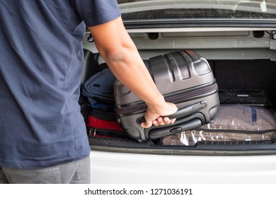 Traveler Pick Up A Suitecase From The Trunk Of The Car