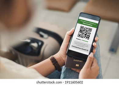 Traveler shows health passport of vaccination certification on phone at airport, to certicy that have been vaccinated of coronavirus covid-19 - Powered by Shutterstock