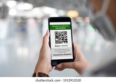 Traveler shows health passport of vaccination certification on phone at airport, to certicy that have been vaccinated of coronavirus covid-19 - Shutterstock ID 1913913520