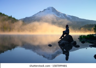traveler sitting on rock and looking over scenic Mount Hood view with sunrise at Trillium Lake, Oregon - Shutterstock ID 1587099481