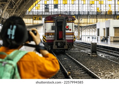 Traveler taking pictures of trains. - Shutterstock ID 2257994585