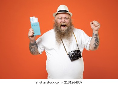 Traveler Tourist Fat Obesy Man In White T-shirt Hat Camera Hold Passport Tickets Do Winner Gesture Clench Fist Isolated On Orange Background Passenger Travel Abroad Weekends On Getaway Journey Concept