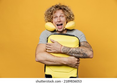 Traveler Tourist Fun Man He Wear Grey T-shirt With Neck Pillow Hold Suitcase Bag Isolated On Plain Yellow Background Studio. Passenger Travel Abroad On Weekends Getaway. Air Flight Journey Concept.