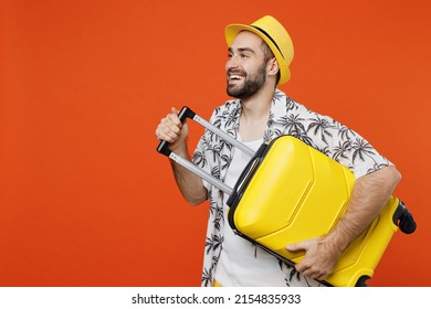 Traveler Tourist Fun Man Wear Summer Casual Clothes Hat Hold Suitcase Bag Look Aside Isolated On Plain Orange Background Studio. Passenger Travel Abroad On Weekends Getaway. Air Flight Journey Concept