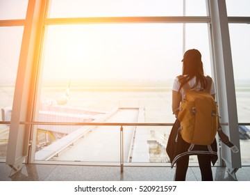 Traveler Tourist Girl And Young Woman Hold Bag In Departure At The Board Terminals Airport Window.  Concept Travel
