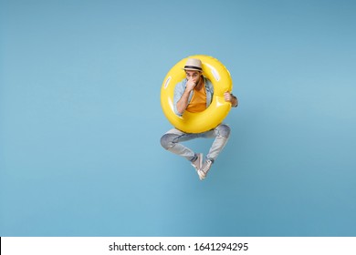 Traveler Tourist Man In Yellow Clothes Isolated On Blue Background. Male Passenger Traveling Abroad On Weekends. Air Flight Journey Concept. Jump Like Diving, Holding Inflatable Ring, Covering Nose