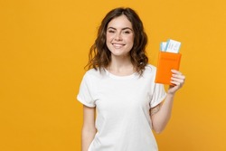 Traveler Tourist Smiling Woman In White T-shirt Hold On Passport With Tickets Look Camera Isolated On Yellow Orange Background. Passenger Traveling Abroad Weekends Getaway. Air Flight Journey Concept