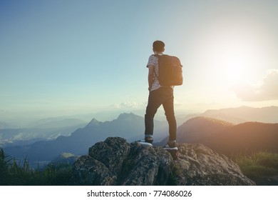 The traveler travel man standing on the top of the hill and enjoy the beautiful scenery, the concept of freedom. - Shutterstock ID 774086026